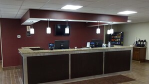 Uma área de recepção com balcão, computadores e máquina de café.