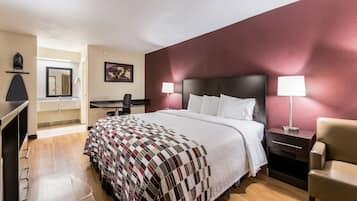 Et hotelværelse med en seng, sengeborde, et skrivebord og en stol.