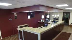 A reception area with a marble counter, a flat-screen TV, and multiple card readers.