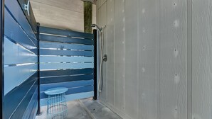 A narrow hallway with a blue bench and a small round table. - Redecorated Pet Friendly Home by RedAwning (Fernandina Beach)