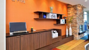 A reception desk with a laptop, a printer, and a sign that reads "Connect & Print". - Fairfield Inn & Suites Sacramento Airport Woodland (Woodland)