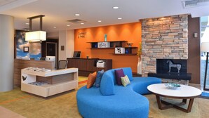 A modern lobby with a reception desk, seating area, and a fireplace. - Fairfield Inn & Suites Sacramento Airport Woodland (Woodland)