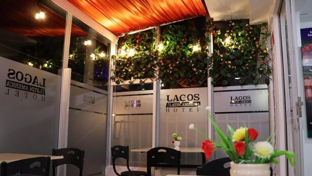 A restaurant with tables and chairs, a wooden ceiling, and decorative plants. - Hotel Lagos Latin America (San Juan de Pasto)
