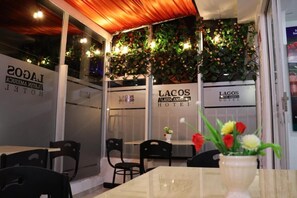 A restaurant with tables and chairs, a wooden ceiling, and decorative plants. - Hotel Lagos Latin America (San Juan de Pasto)