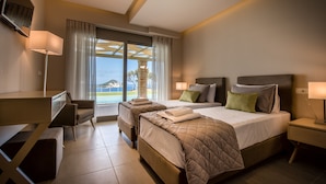 A hotel room with two beds, a desk, and a large window with a view.