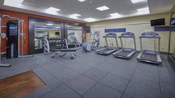 A gym with treadmills, weight machines, and free weights.