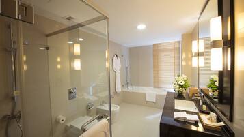 A modern bathroom with a glass-enclosed shower, a separate toilet, a bathtub, and a vanity with a mirror.