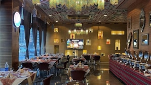 A restaurant with a traditional design, featuring ornate chandeliers, patterned walls, and a buffet setup. - Asdal Boutique Hotel Seef (Manama)