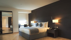 A modern hotel room with a large bed, bedside lamps, a bedside table, and a mirror. - Asdal Boutique Hotel Seef (Manama)
