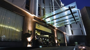 A hotel entrance with a glass facade, a visible sign for the Gulf Inn, and a well-lit pathway leading to the entrance. - Asdal Boutique Hotel Seef (Manama)