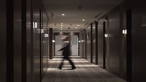 A corridor with a patterned carpet, doors on both sides, and recessed lighting on the ceiling. - Asdal Boutique Hotel Seef (Manama)