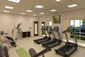Sala de ginástica equipada com esteiras, bicicleta ergométrica e máquina de remo.