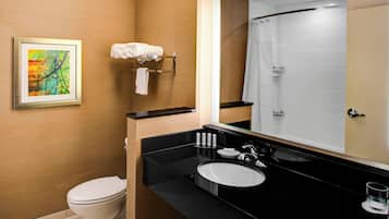 Un baño moderno con inodoro, lavamanos y ducha.