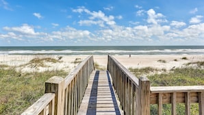 A wooden boardwalk leading to a beach with sand dunes and the ocean in the background. - 812 S. Fletcher - 3 Br Cottage (Fernandina Beach)
