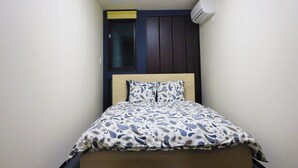 Une chambre à coucher comprenant un lit, une armoire et un appareil de climatisation.