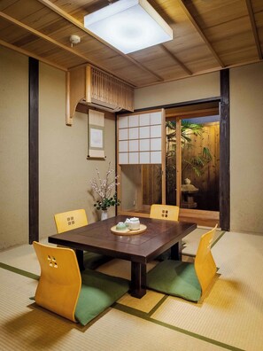 Une pièce de style japonais traditionnel, avec un sol recouvert de tatamis, une table basse et des paravents en papier.