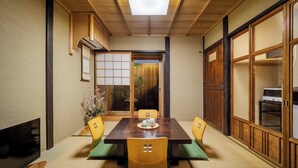 Una habitación tradicional japonesa con suelo de tatami, una mesa baja y puertas correderas.