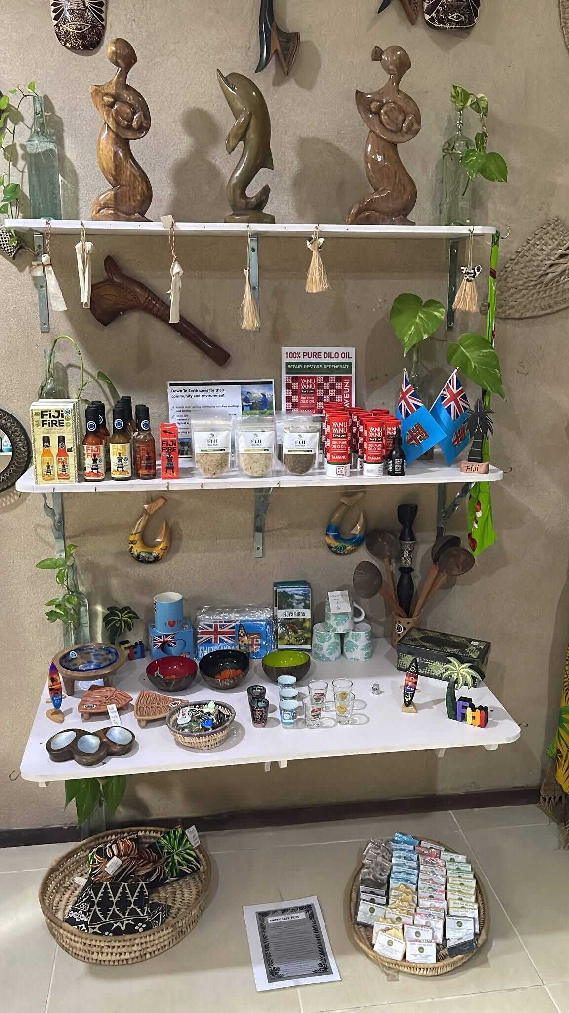 Exposição de diversos objetos, incluindo garrafas, um letreiro sobre óleo puro Dilo, e uma mesa com tigelas e outros itens.