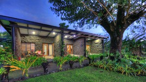 A modern house with a stone facade, large windows, and a covered porch. - Paradise Taveuni (Taveuni Island West)