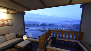 Ein Zimmer mit Holzterrasse, Whirlpool und einer Couch.