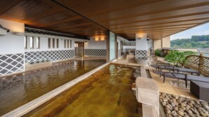 Ein Wellnessbereich mit Holzboden, einem Pool und Sitzgelegenheiten im Freien.