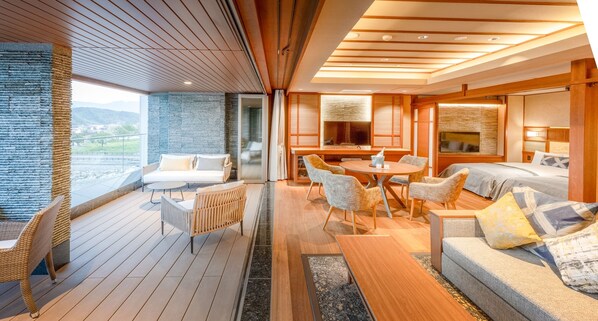 A modern interior with a wooden deck, a dining area, and a bedroom with a large window. - Hotel & Ryokan Ayunosato (Hitoyoshi)