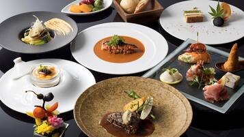 Una variedad de platos en una mesa, que incluyen mariscos, carne y verduras, sugiriendo una experiencia gastronómica de alta calidad.