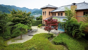 A traditional building with a garden, a view of the mountains, and a dining area with tables and chairs. - The Hamilton Ureshino (Ureshino)
