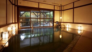 An indoor swimming pool with a view of a garden through large windows. - The Hamilton Ureshino (Ureshino)