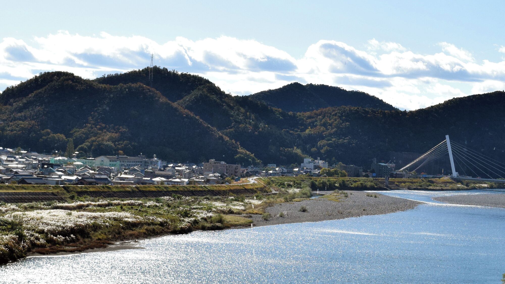 A coastal town with a bridge, hills, and a river.