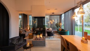 Una sala de estar moderna con chimenea, sofás y un comedor.