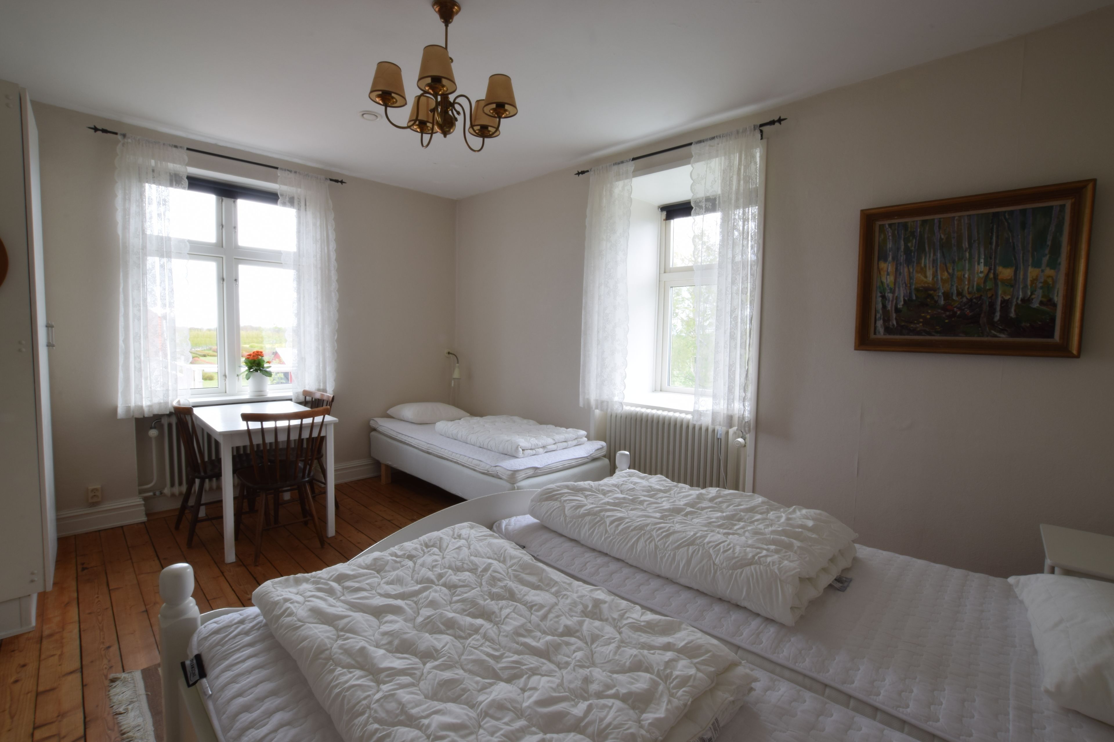 Ein Schlafzimmer mit zwei Betten, einem Schreibtisch und einem Stuhl.