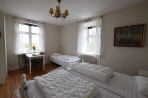 Un dormitorio con dos camas, un escritorio y una silla.