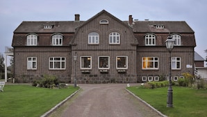 A large, two-story brick building with a symmetrical facade, a central entrance, and a gravel driveway. - Bläsinge Gård Kullabygden - Hostel (Jonstorp)