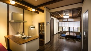A modern kitchen with a wooden countertop, built-in microwave, and a sink. - KYOTO yadomachi Kamishichiken (Kyoto)