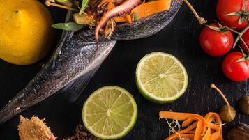 A seafood dish with shrimp, scallops, and vegetables on a dark surface.