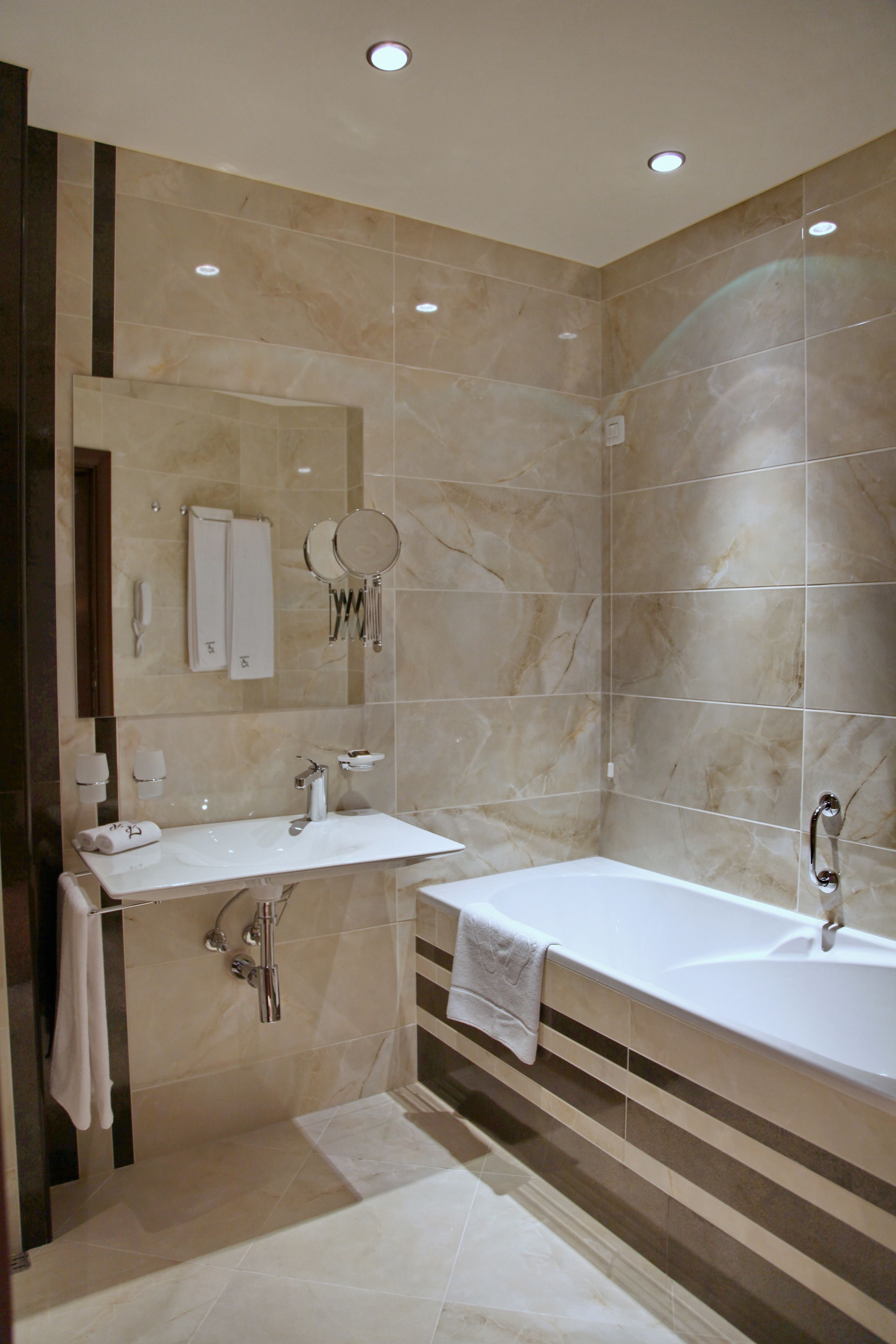 Un baño moderno con una bañera grande, dos lavamanos y un tocador.