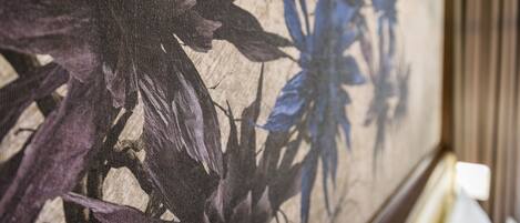 A close-up of a floral tapestry on a wall.