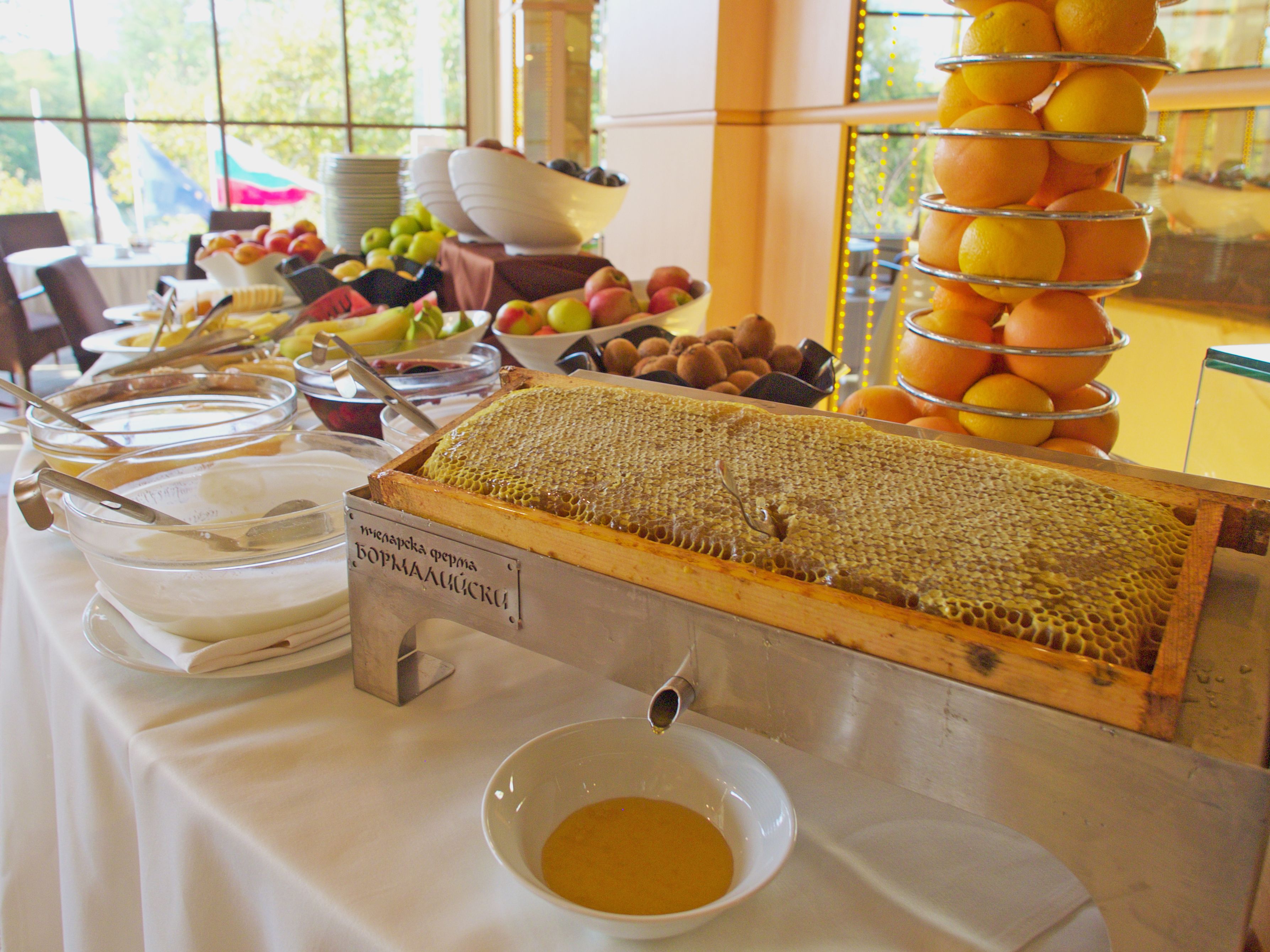 A buffet table with various food items, including fruits and a honeycomb display.