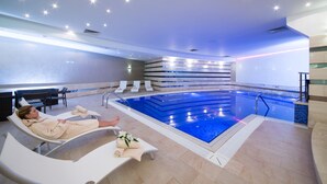 Un espace piscine avec des chaises longues et une personne se relaxant.