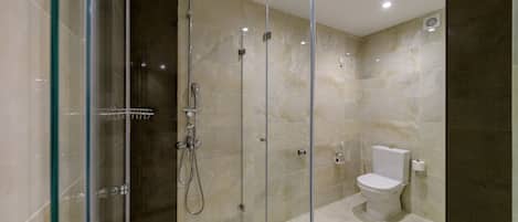 A modern bathroom with a glass-enclosed shower, a toilet, and a marble-tiled floor.
