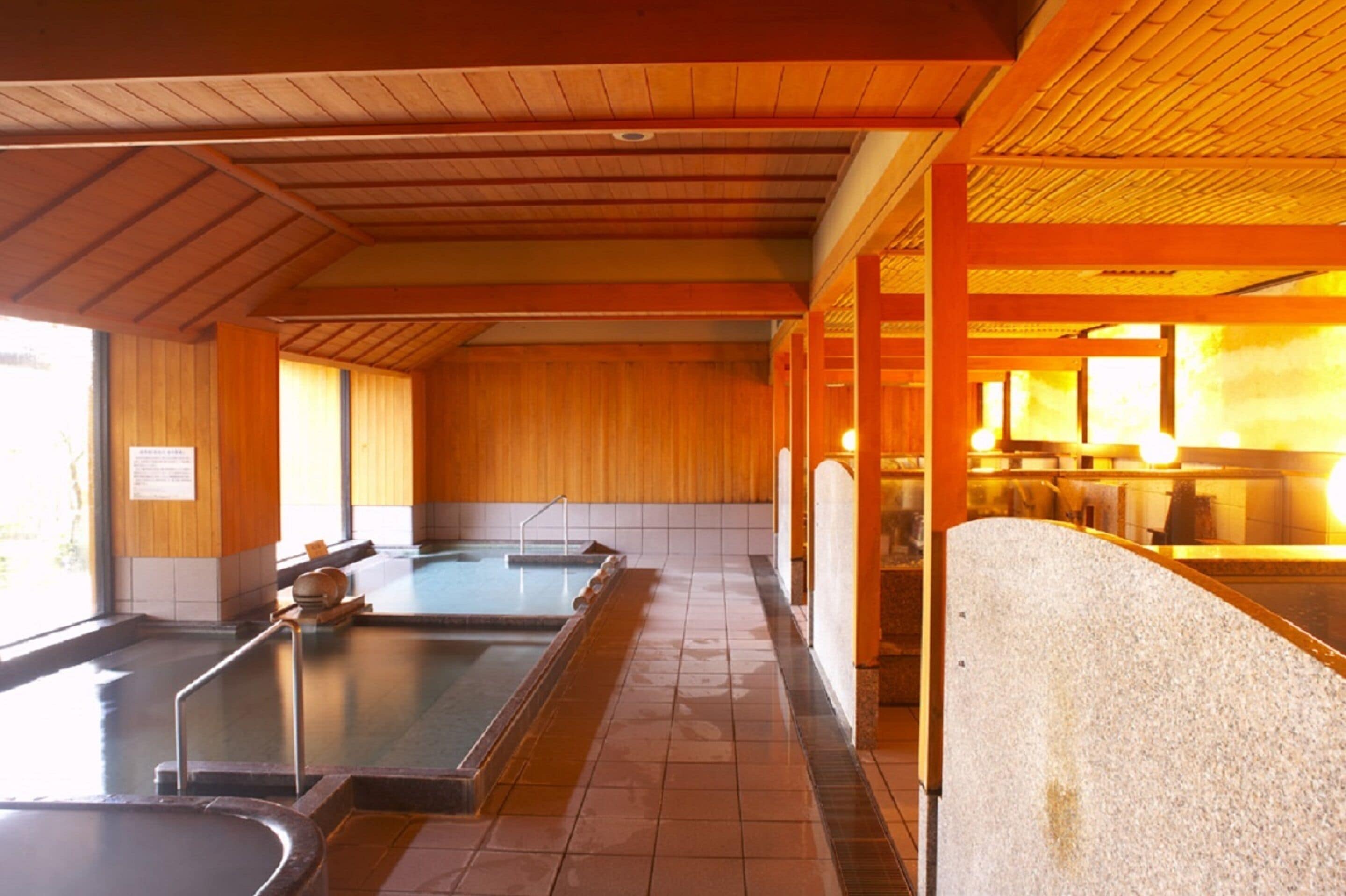 A traditional Japanese onsen with wooden interiors and multiple hot spring baths.