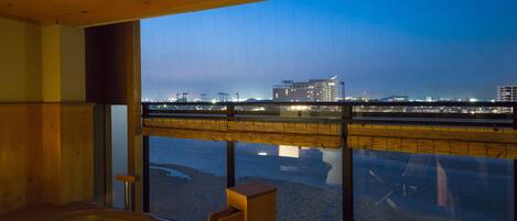 A spa area with a hot tub and a large window overlooking a cityscape at dusk.