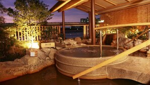 A hot spring bath area with a wooden structure, rocks, and a sign indicating it is a public bath. - Juhachiro (Gifu)