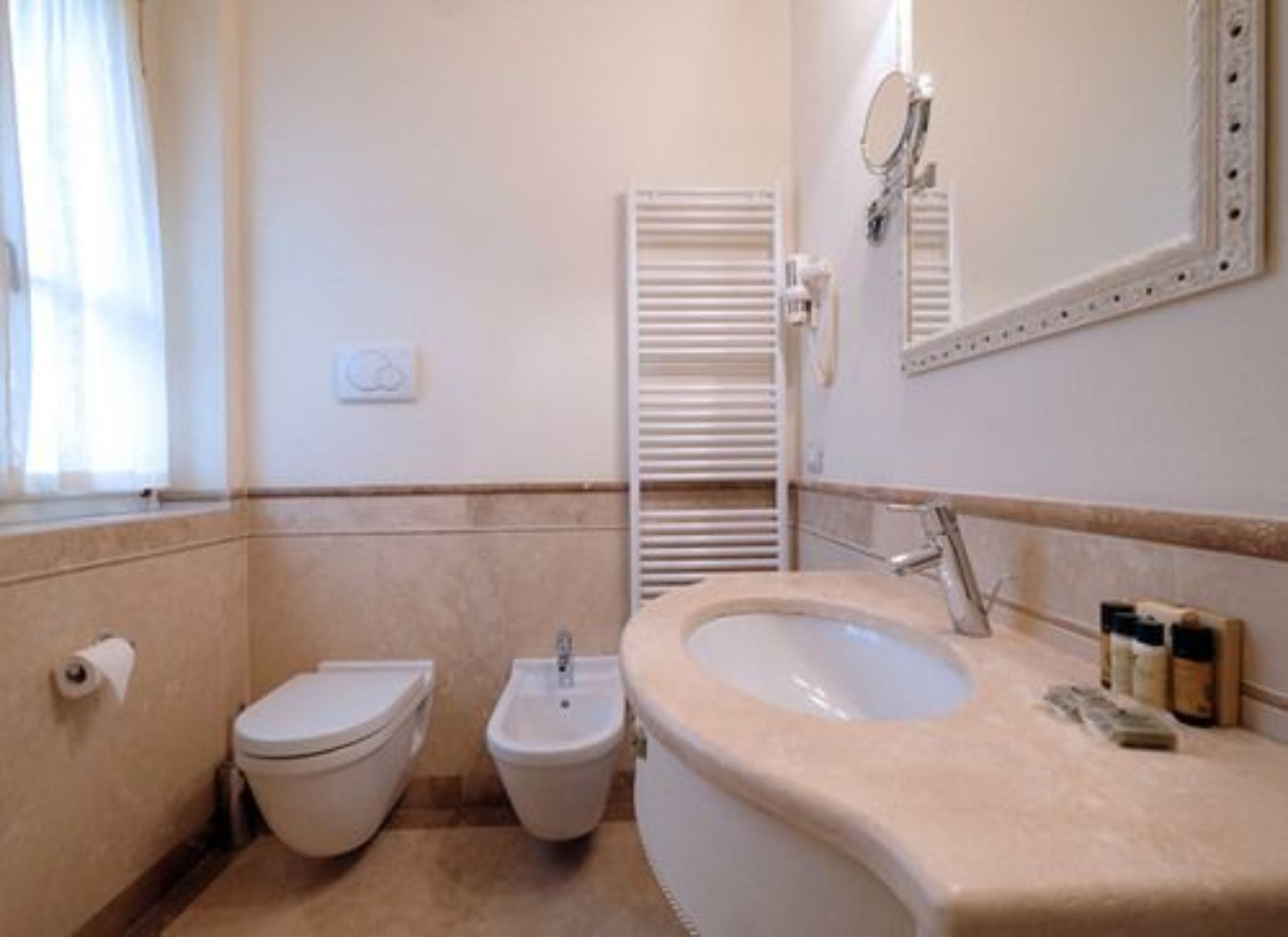 Une salle de bain équipée de toilettes, d’un bidet et d’un lavabo.