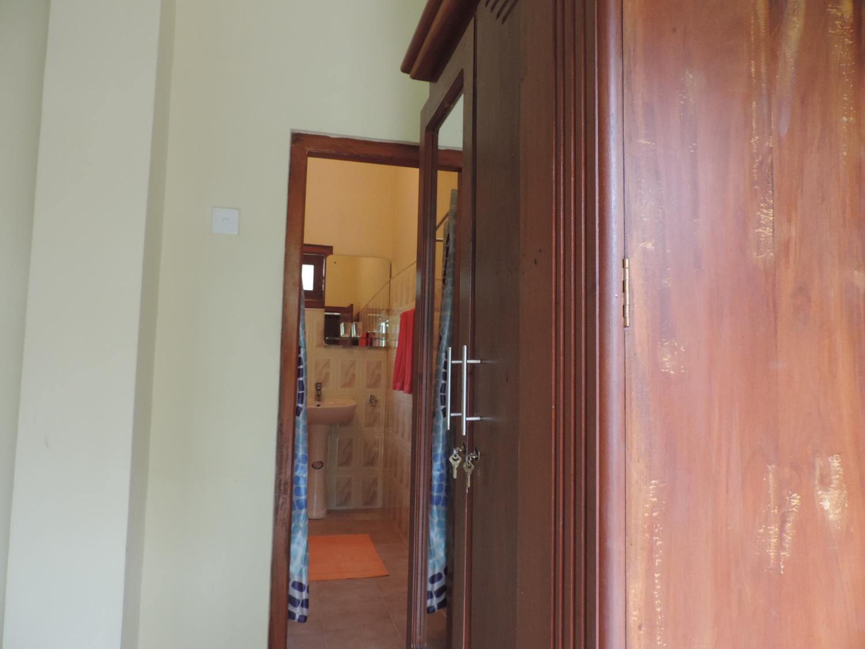 A hallway leading to a bathroom with a sink and a mirror.