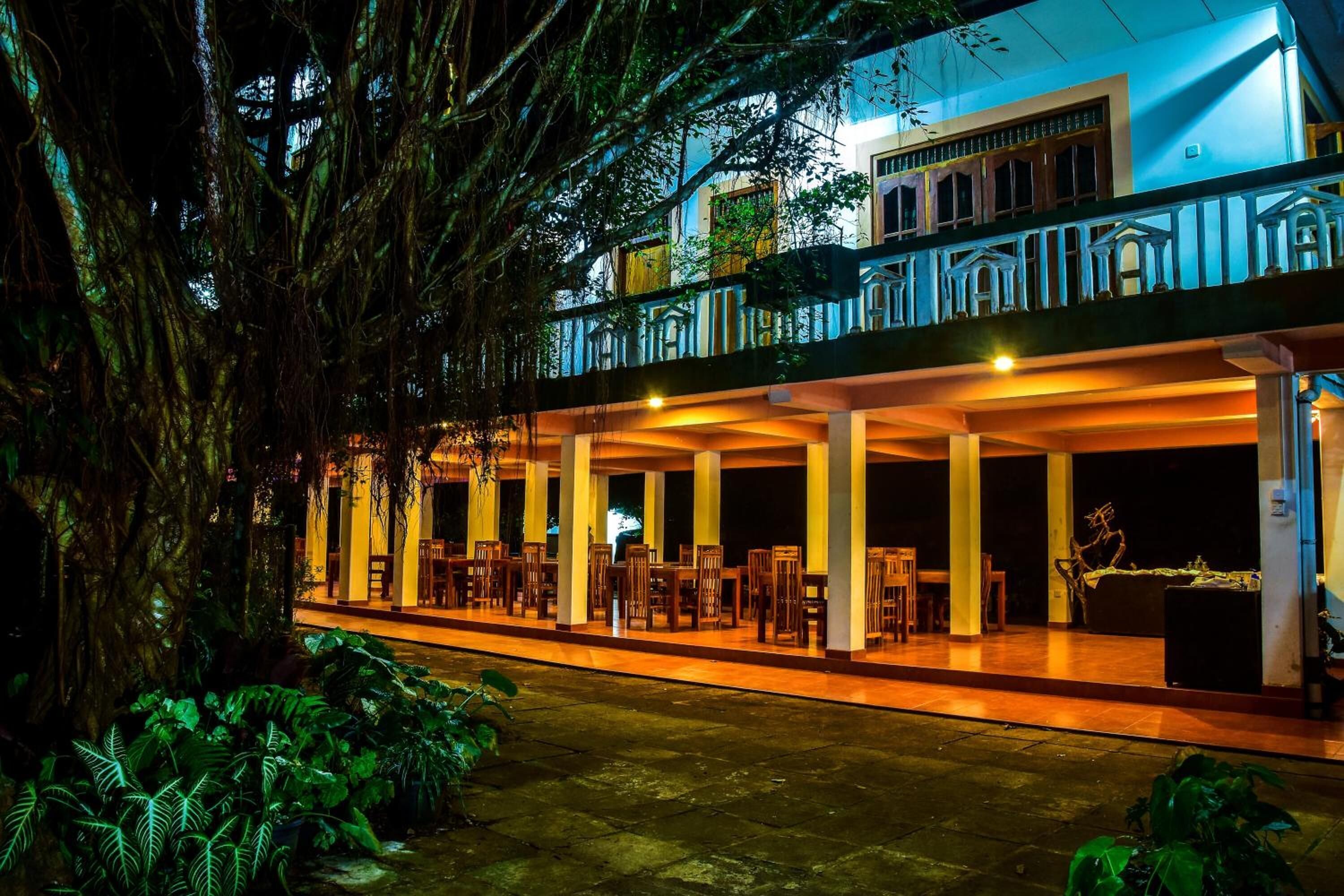A two-story building with a balcony and outdoor seating area.