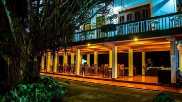 A two-story building with a balcony and outdoor seating area.