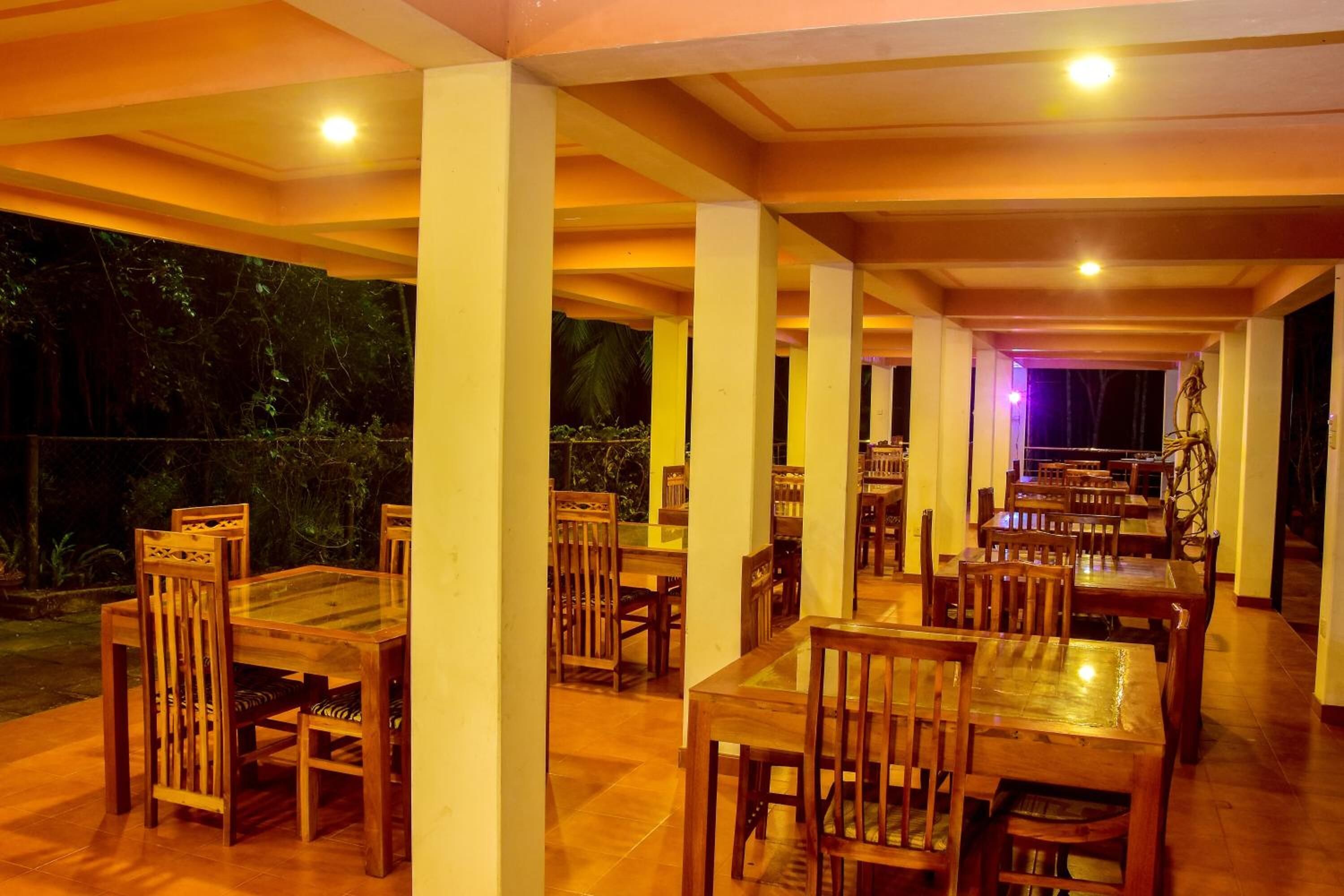 A restaurant with wooden tables and chairs, a tiled floor, and a view of the outdoors.