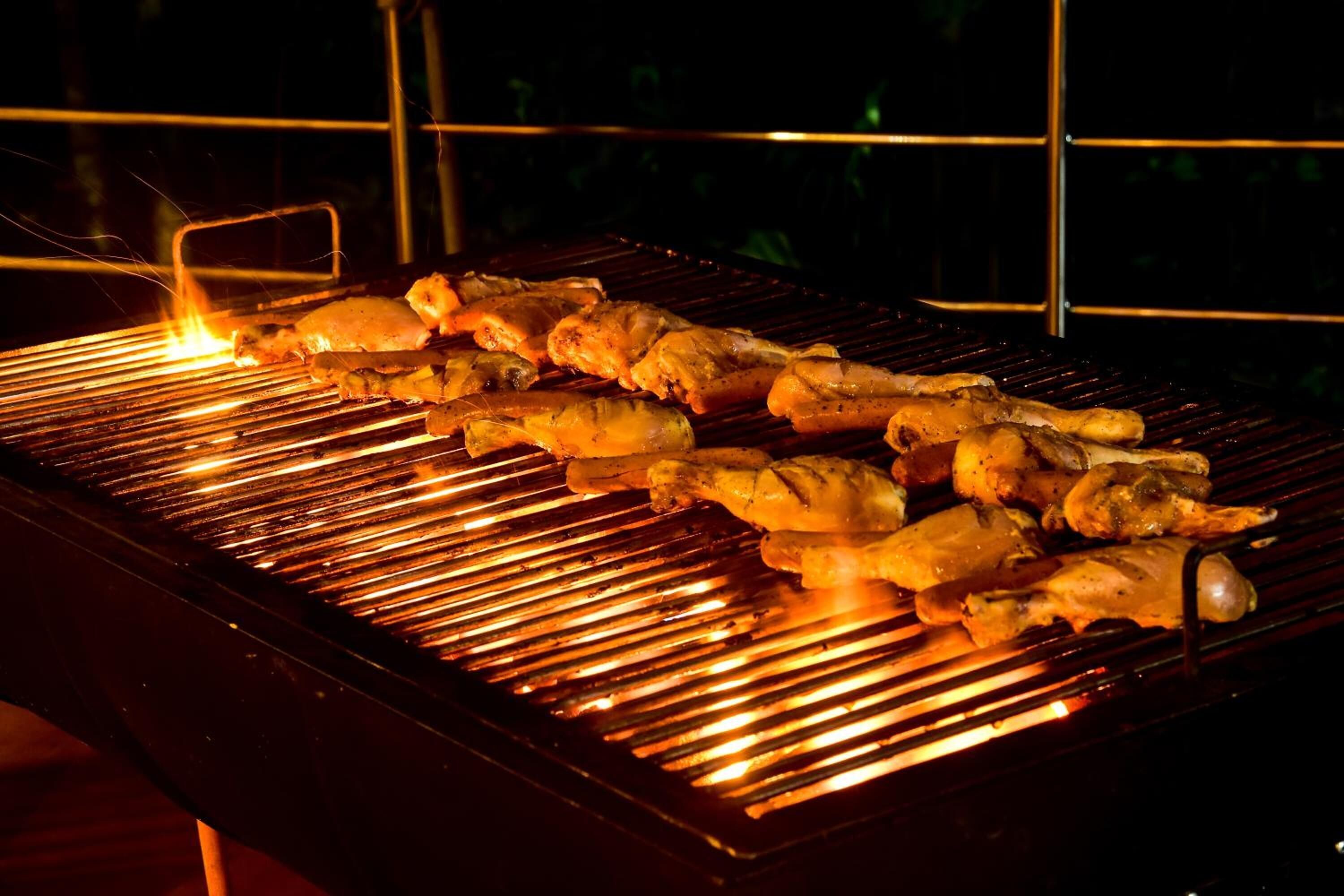 A grill with skewered food items being cooked.